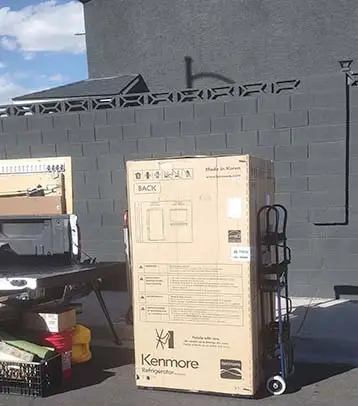 Refridgerator on an appliance dolly behind a pickup truck from help moving service